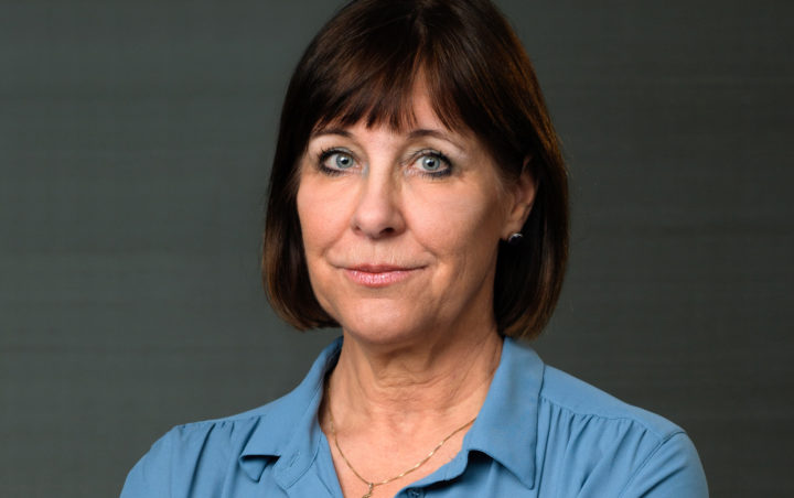 Kvinna med brunt hår och ljusblå blus