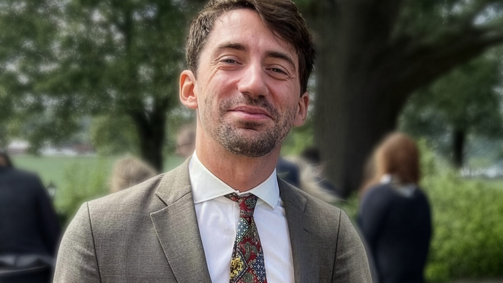 Proträttbild av Peter von Scheele mot en grön fond av växter.
