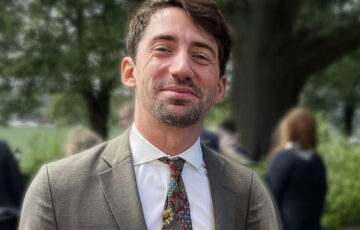 Proträttbild av Peter von Scheele mot en grön fond av växter.
